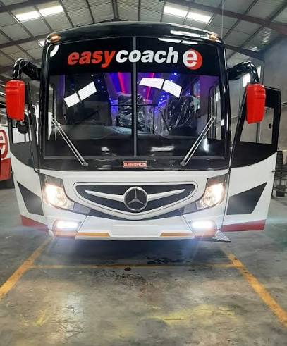 Easy Coach Mercedes-Benz coach with headlights on in the garage
